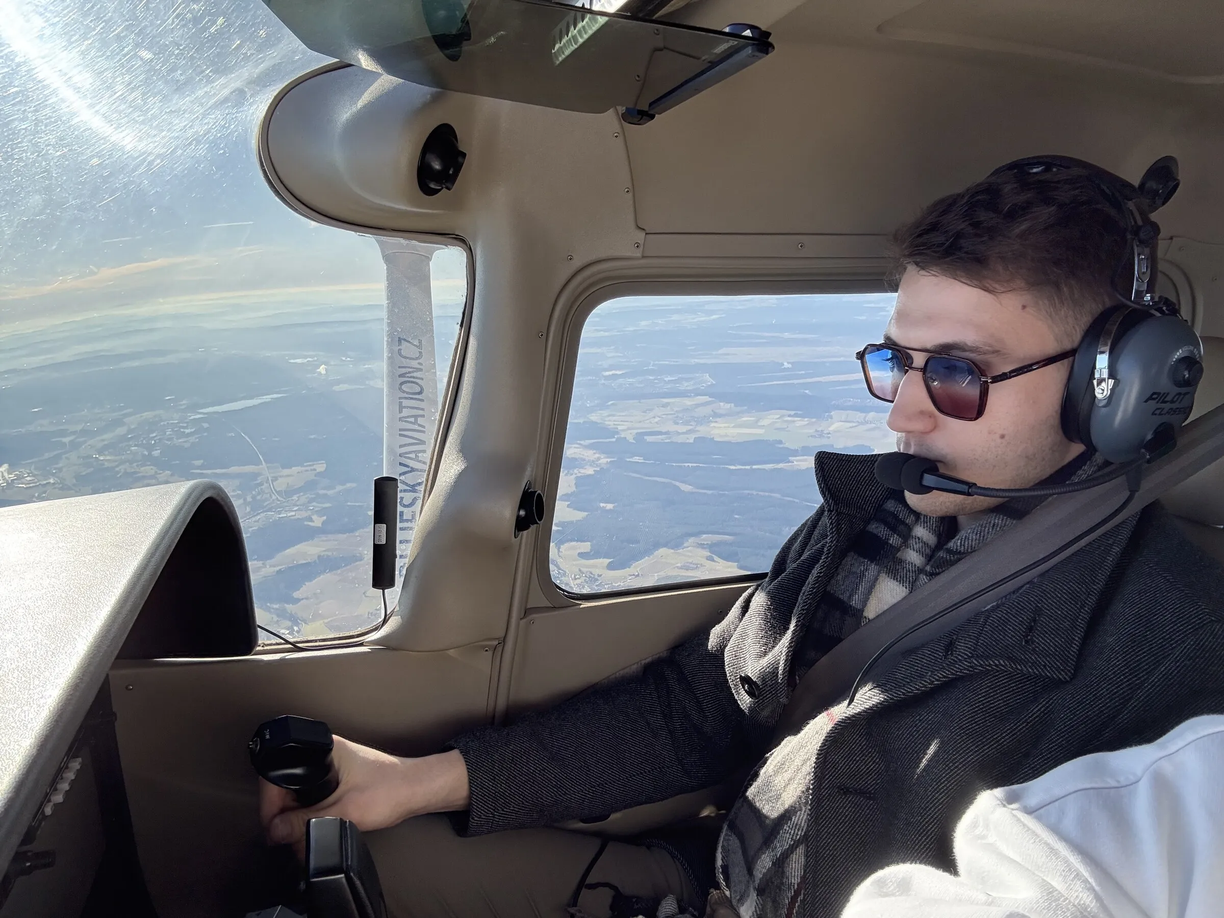 Tomáš Palas za řízením malého letadla s pilotními sluchátky
